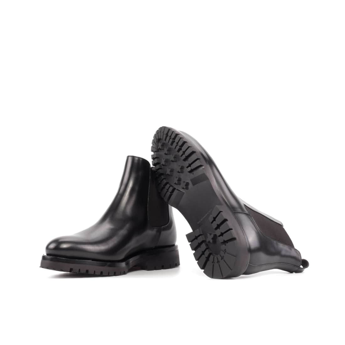 Chelsea boots en cuir noir, l’une couchée qui montre sa semelle Commando crantée