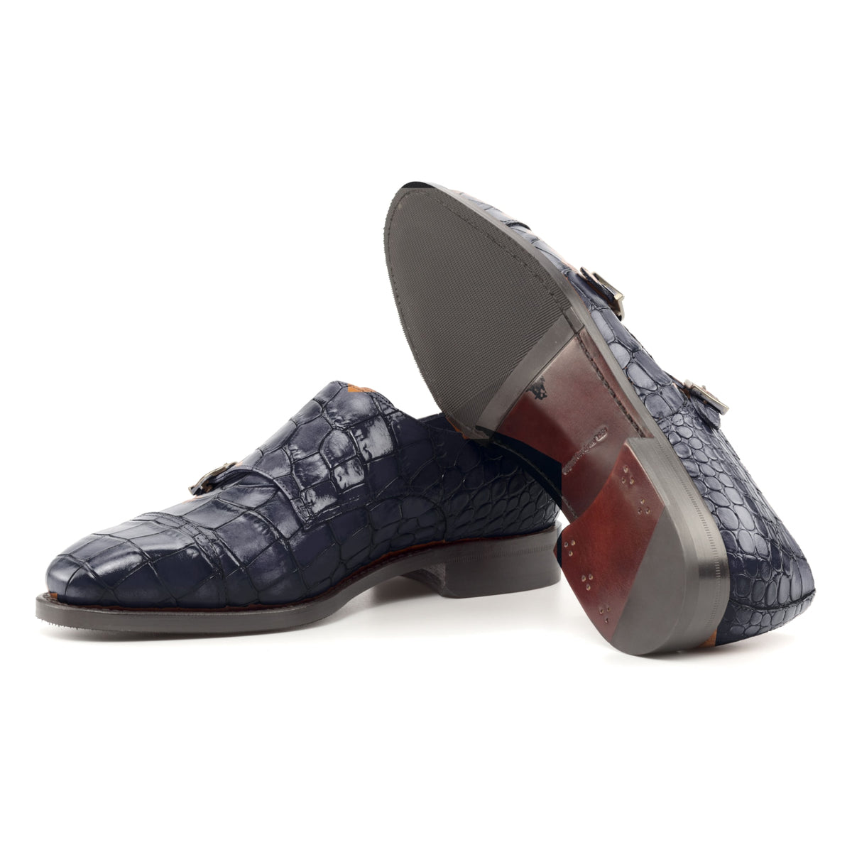 Chaussure double boucle en cuir croco bleu marine : une chaussure debout, l’autre couchée montre sa semelle