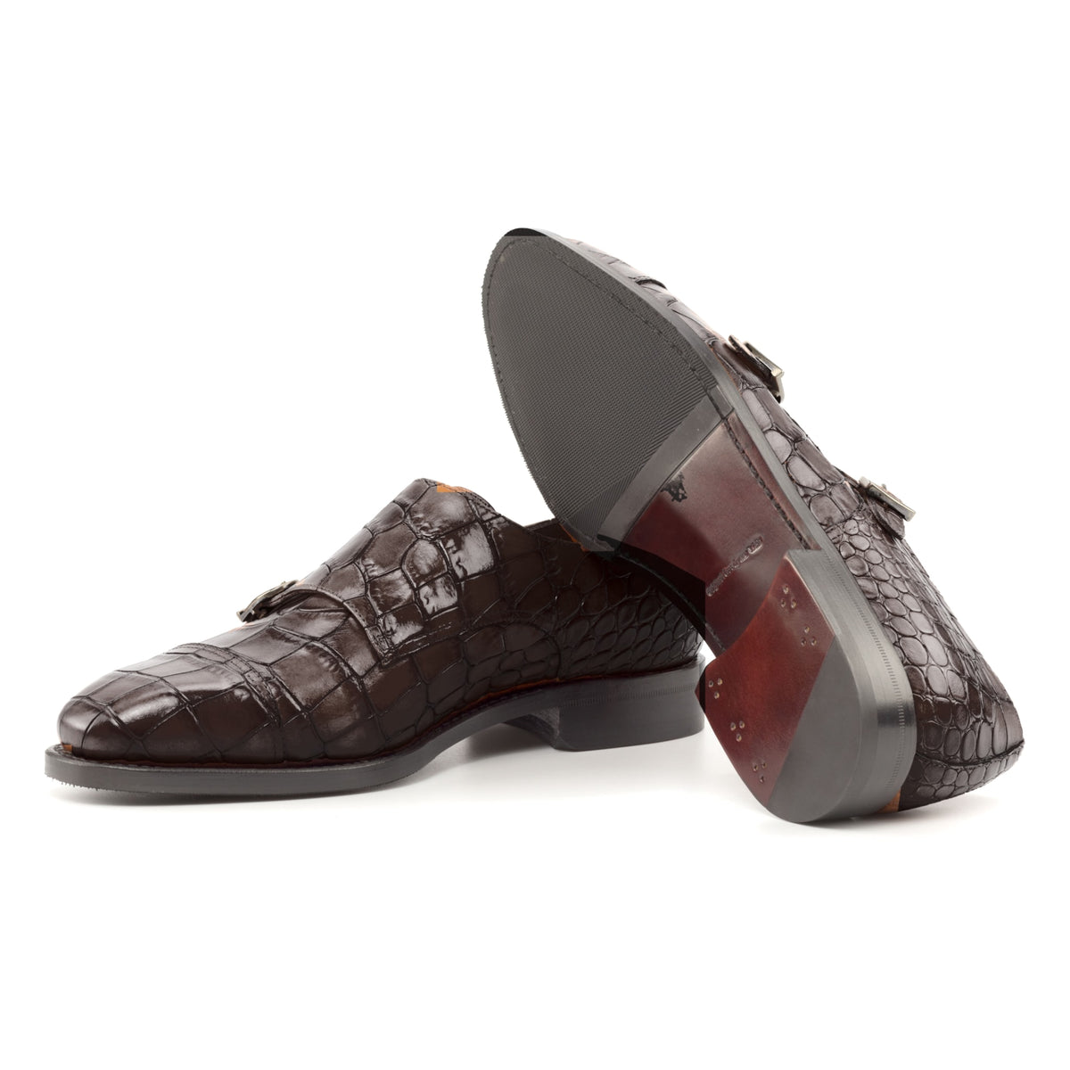 Chaussure double boucle en cuir croco marron foncé : une chaussure debout, l’autre couchée montre sa semelle