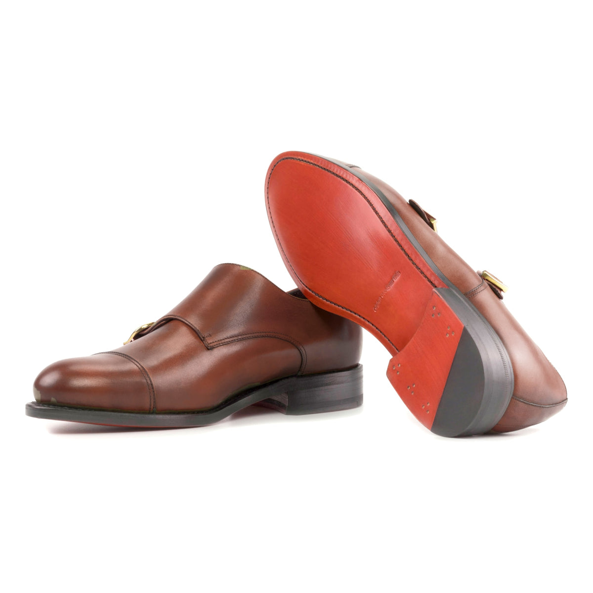 Chaussure double boucle en cuir teinté main marron moyen : une chaussure debout, l’autre couchée montre sa semelle