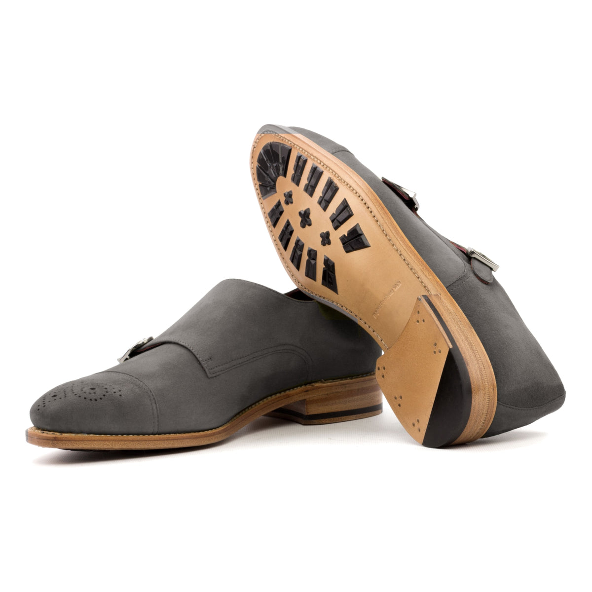 Chaussure double boucle en daim gris : une chaussure debout, l’autre couchée montre sa semelle
