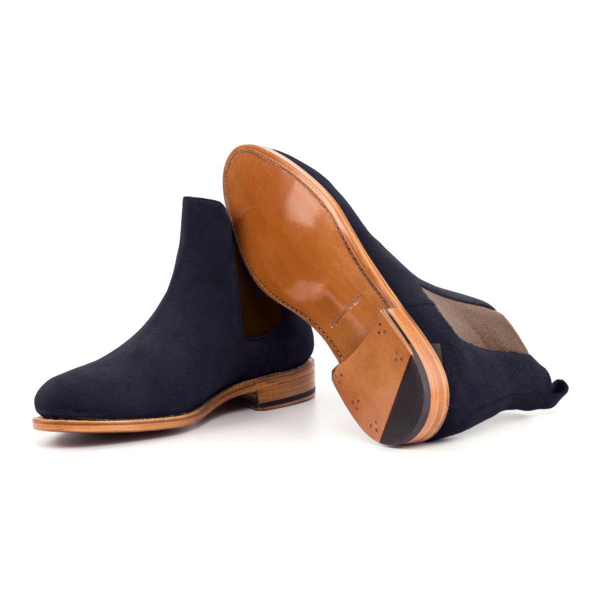 Chelsea Boots en daim bleu marine, semelle cuir : une bottine debout, l’autre couchée montre sa semelle