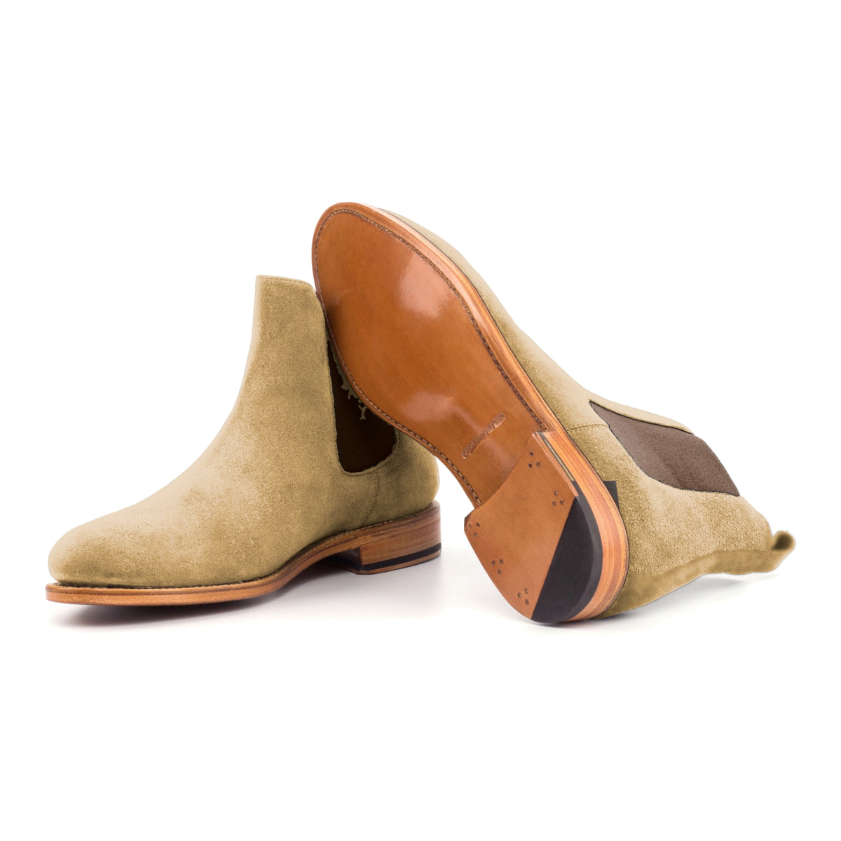 Chelsea Boots en daim camel, semelle cuir : une bottine debout, l’autre couchée montre sa semelle