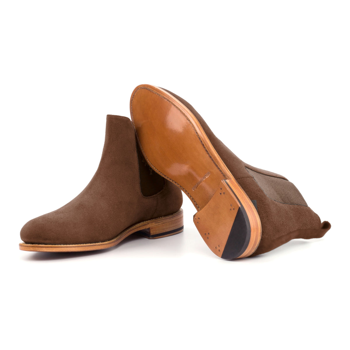 Chelsea Boots en daim marron moyen, semelle cuir : une bottine debout, l’autre couchée montre sa semelle