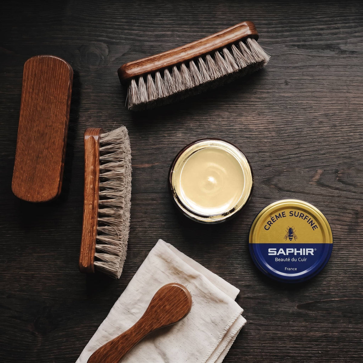 Crème Surfine Saphir Or Trianon en pot ouvert, avec des brosses en crin et une chamoisine, vue de dessus