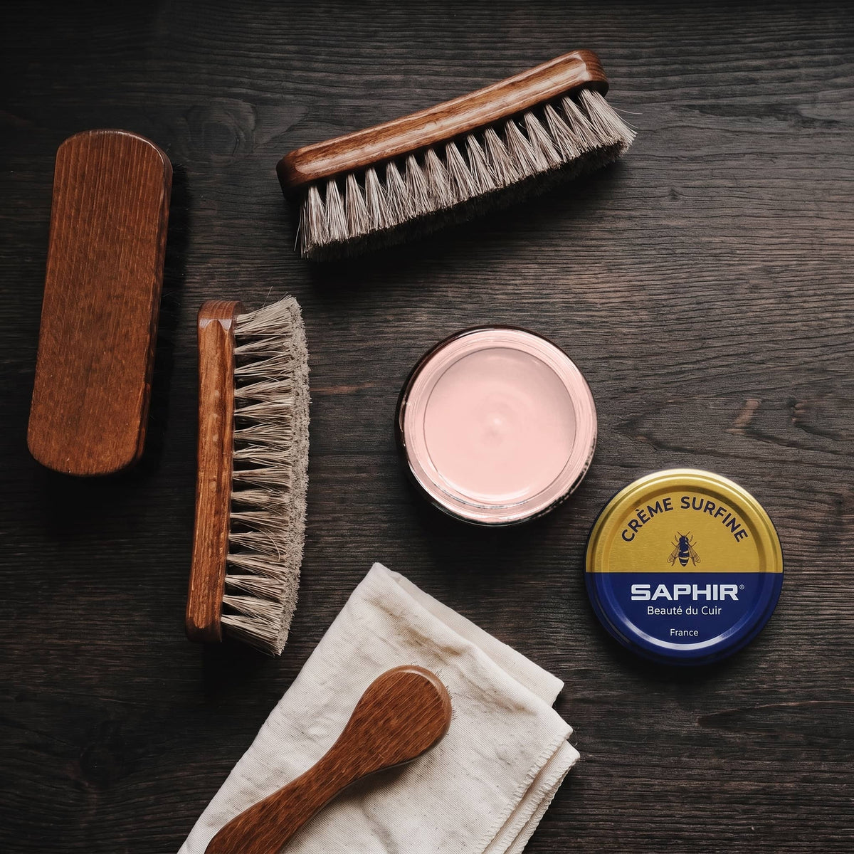 Crème Surfine Saphir Rose en pot ouvert, avec des brosses en crin et une chamoisine, vue de dessus