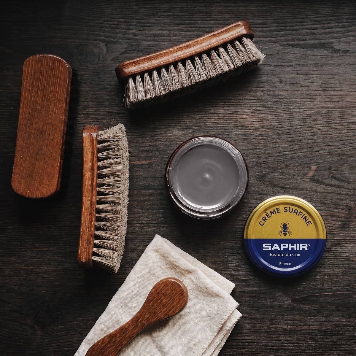 Crème Surfine Saphir Vison en pot ouvert, avec des brosses en crin et une chamoisine, vue de dessus