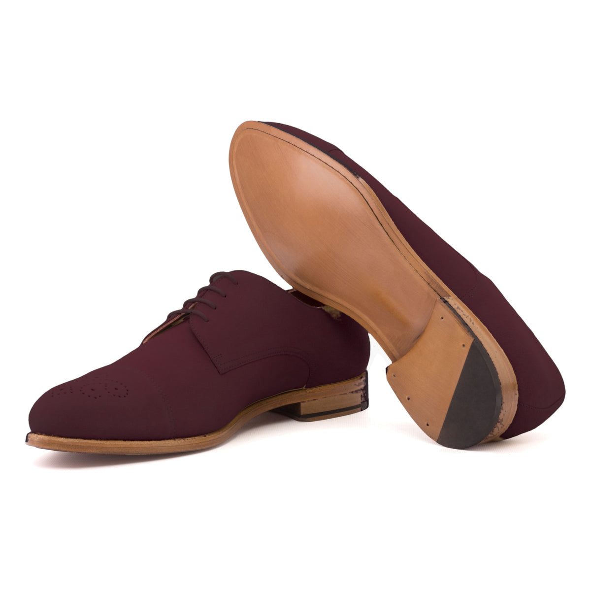 Derby bout droit fleuri en daim bordeaux, semelle cuir : une chaussure debout, l’autre couchée montre sa semelle