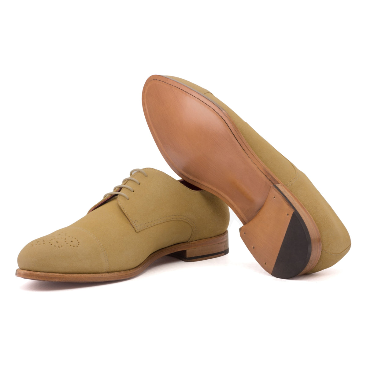 Derby bout droit fleuri en daim camel, semelle cuir : une chaussure debout, l’autre couchée montre sa semelle