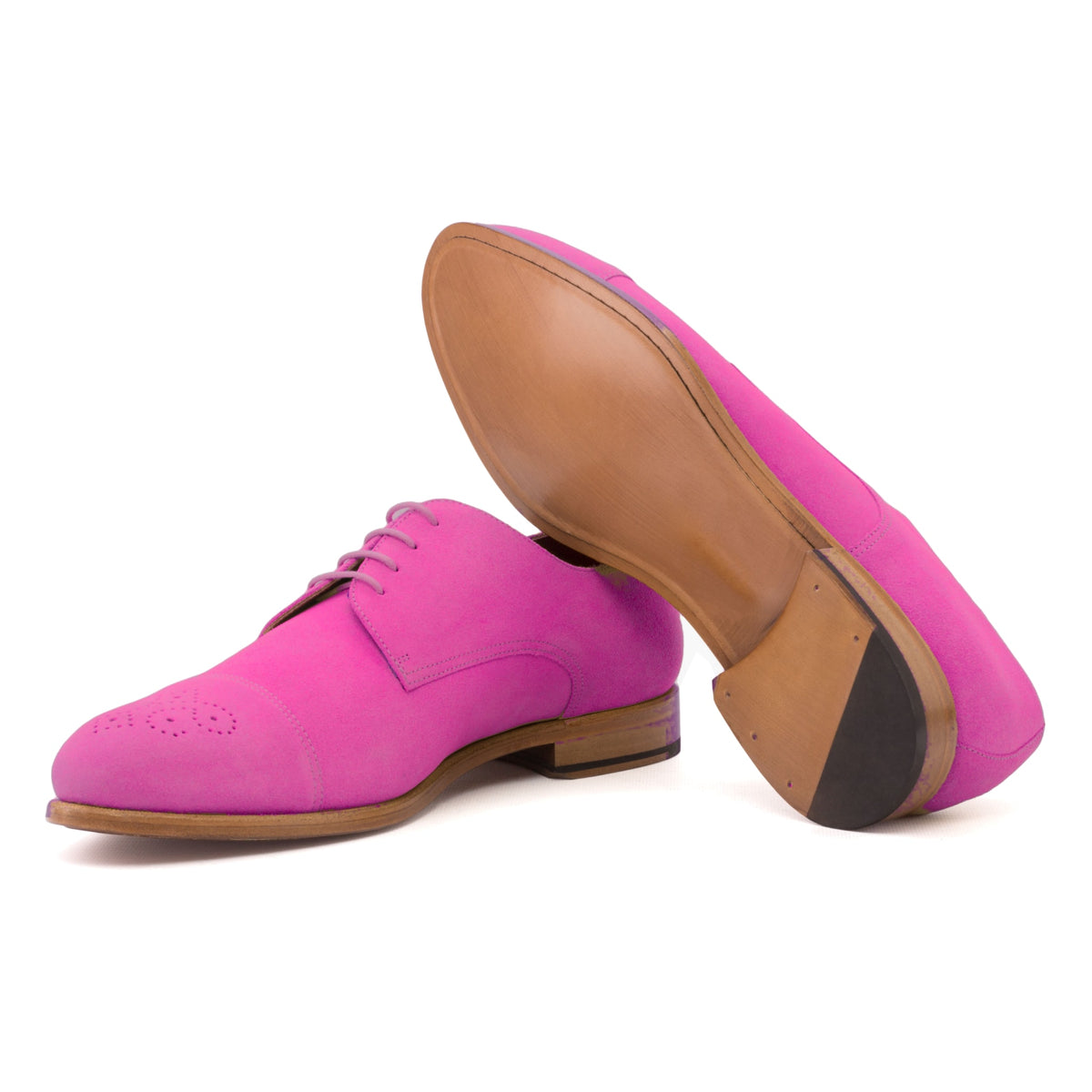 Derby bout droit fleuri en daim de chevreau fuchsia, semelle cuir : une chaussure debout, l’autre couchée montre sa semelle