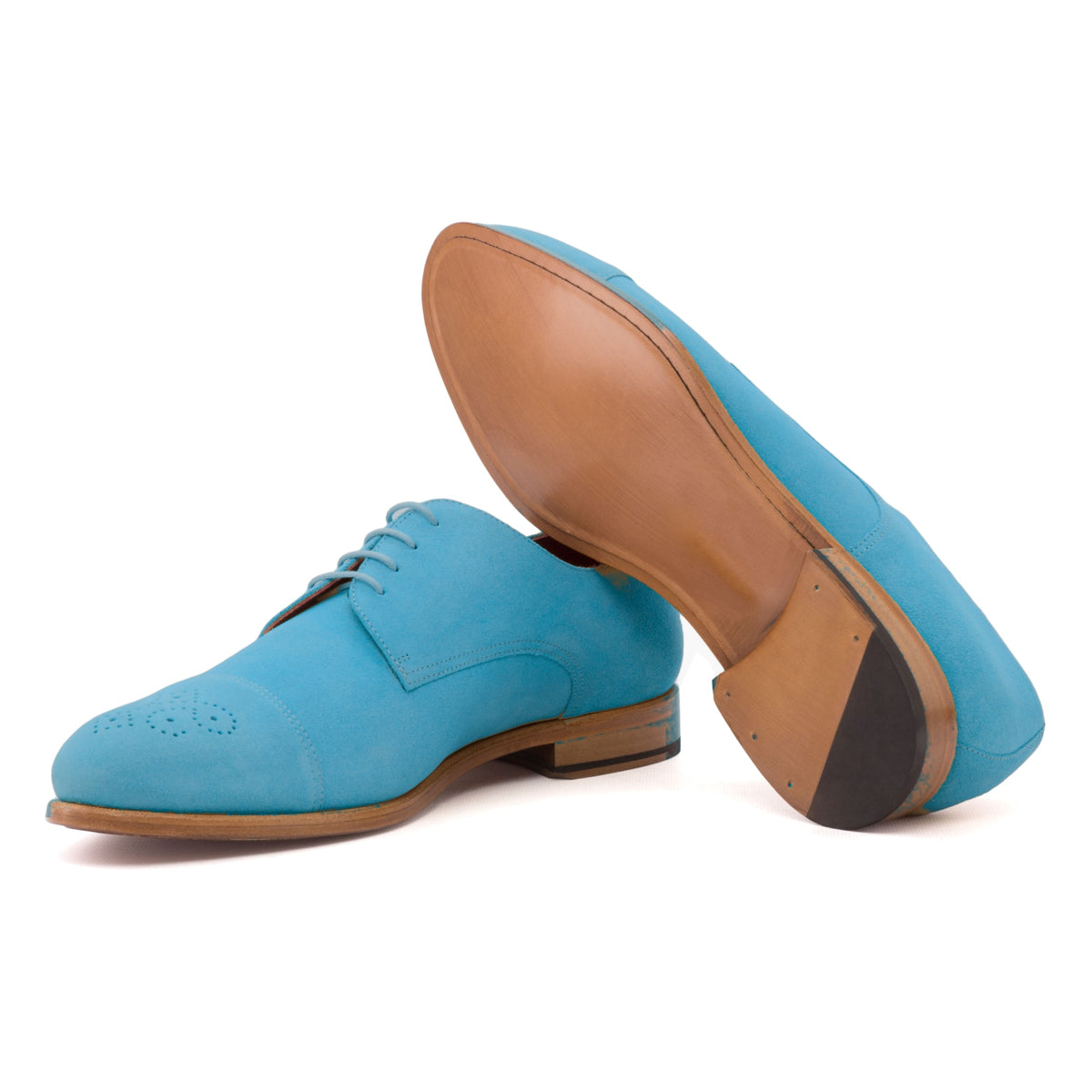 Derby bout droit fleuri en daim de chevreau turquoise, semelle cuir : une chaussure debout, l’autre couchée montre sa semelle