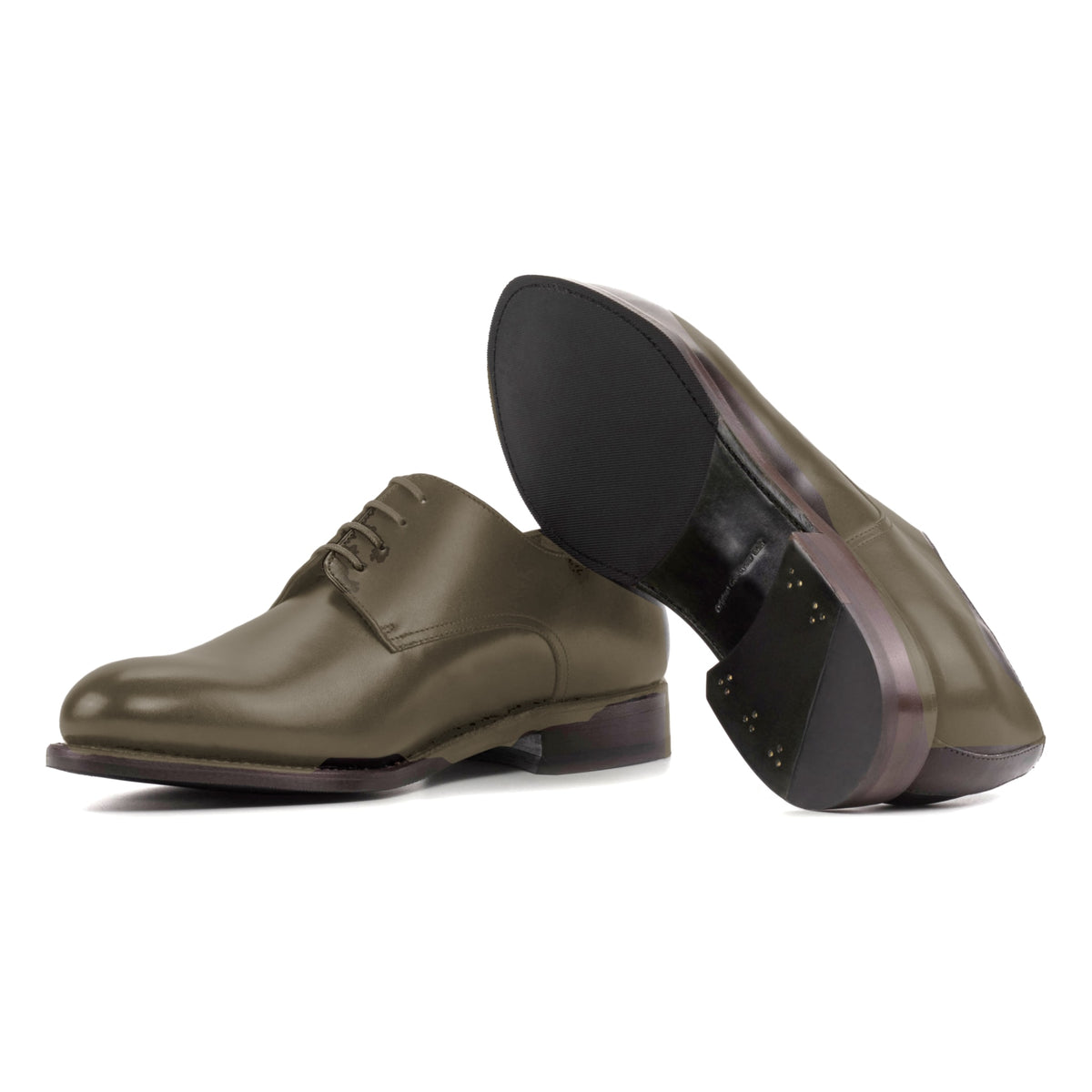 Derby en cuir teinté main vert olive, semelle cuir et patin : une chaussure debout, l’autre couchée montre sa semelle