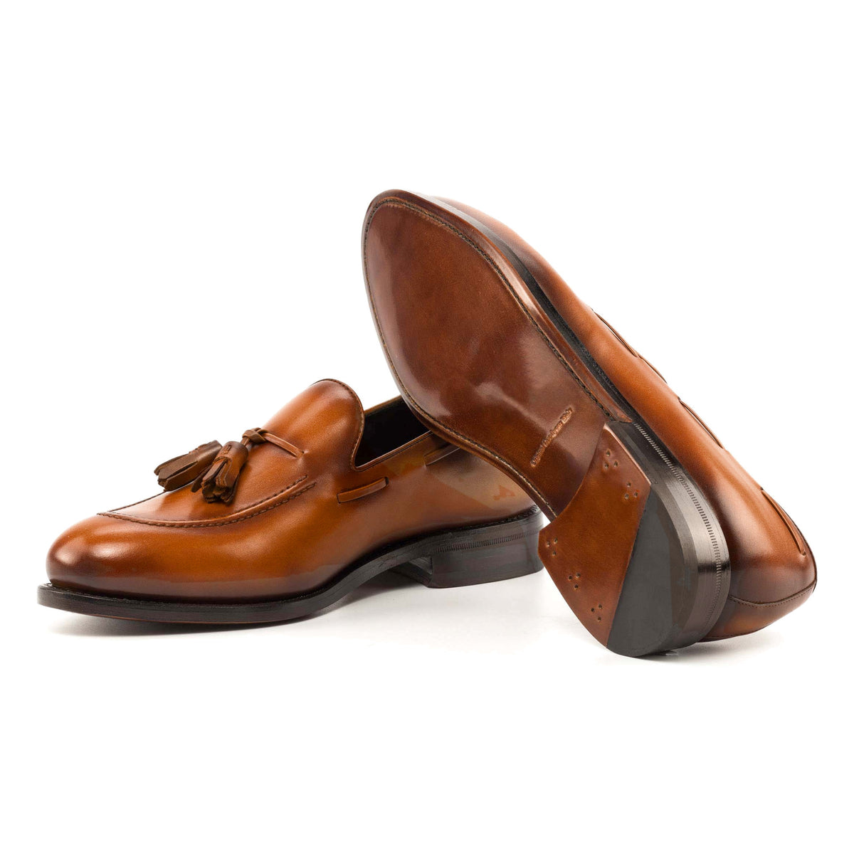 Mocassin à glands en cuir teinté main cognac : une chaussure couchée montre la semelle