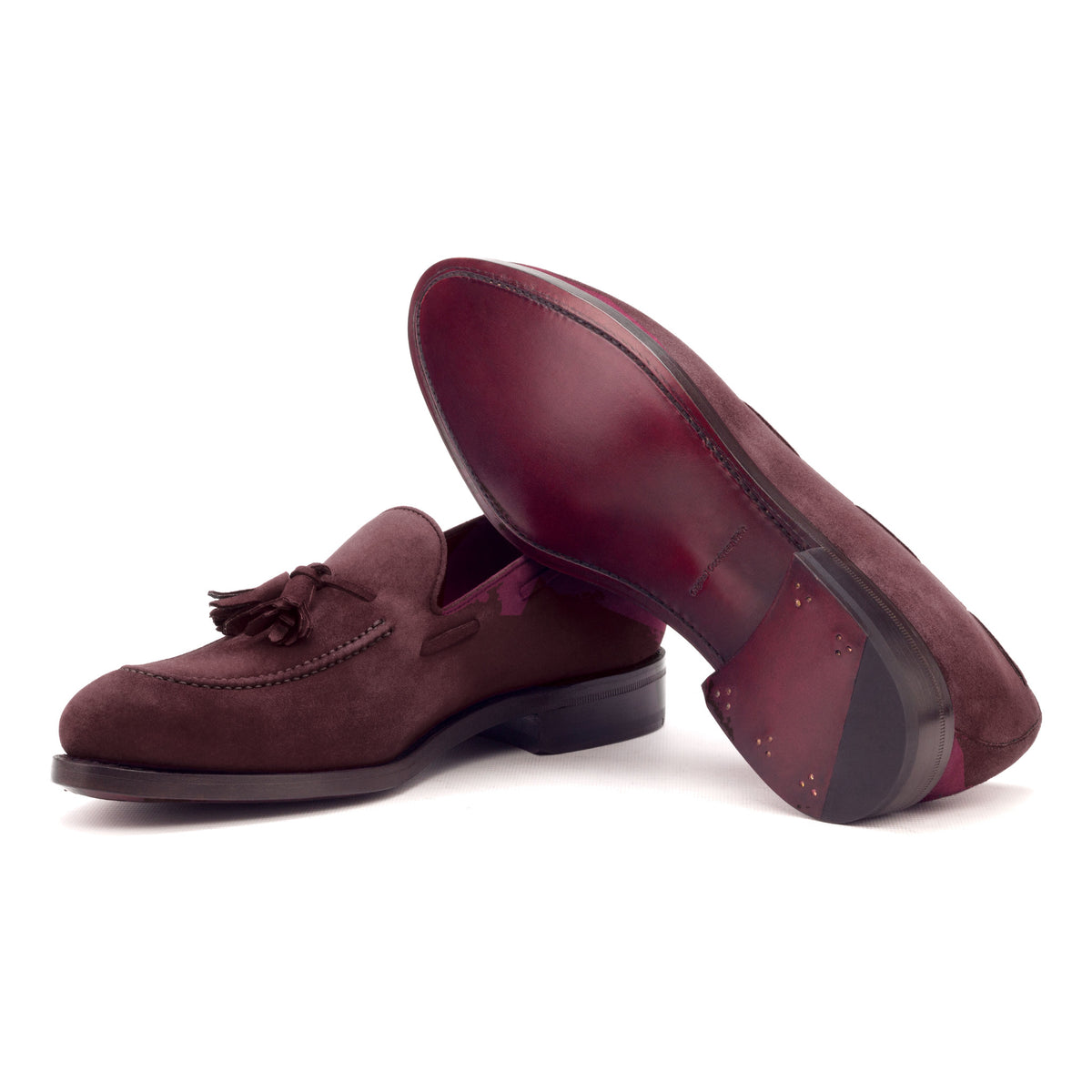 Mocassin à glands en daim bordeaux : une chaussure couchée montre la semelle