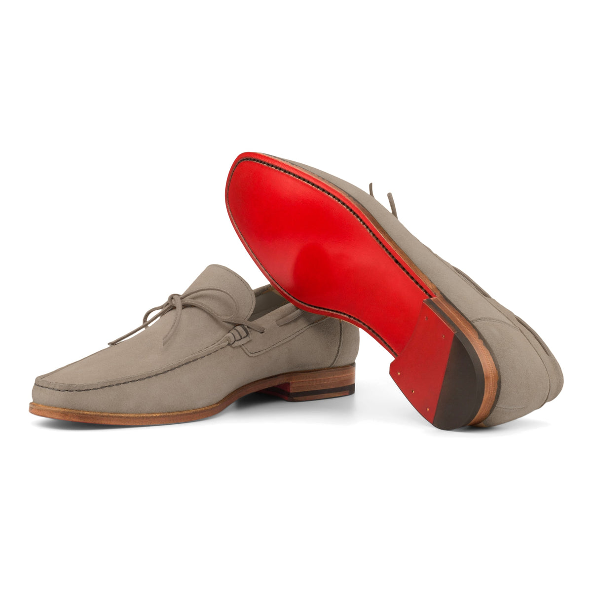 Mocassin bateau en daim gris : une chaussure couchée montre la semelle
