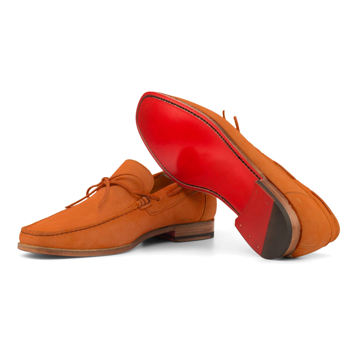 Mocassin bateau en daim orange : une chaussure couchée montre la semelle