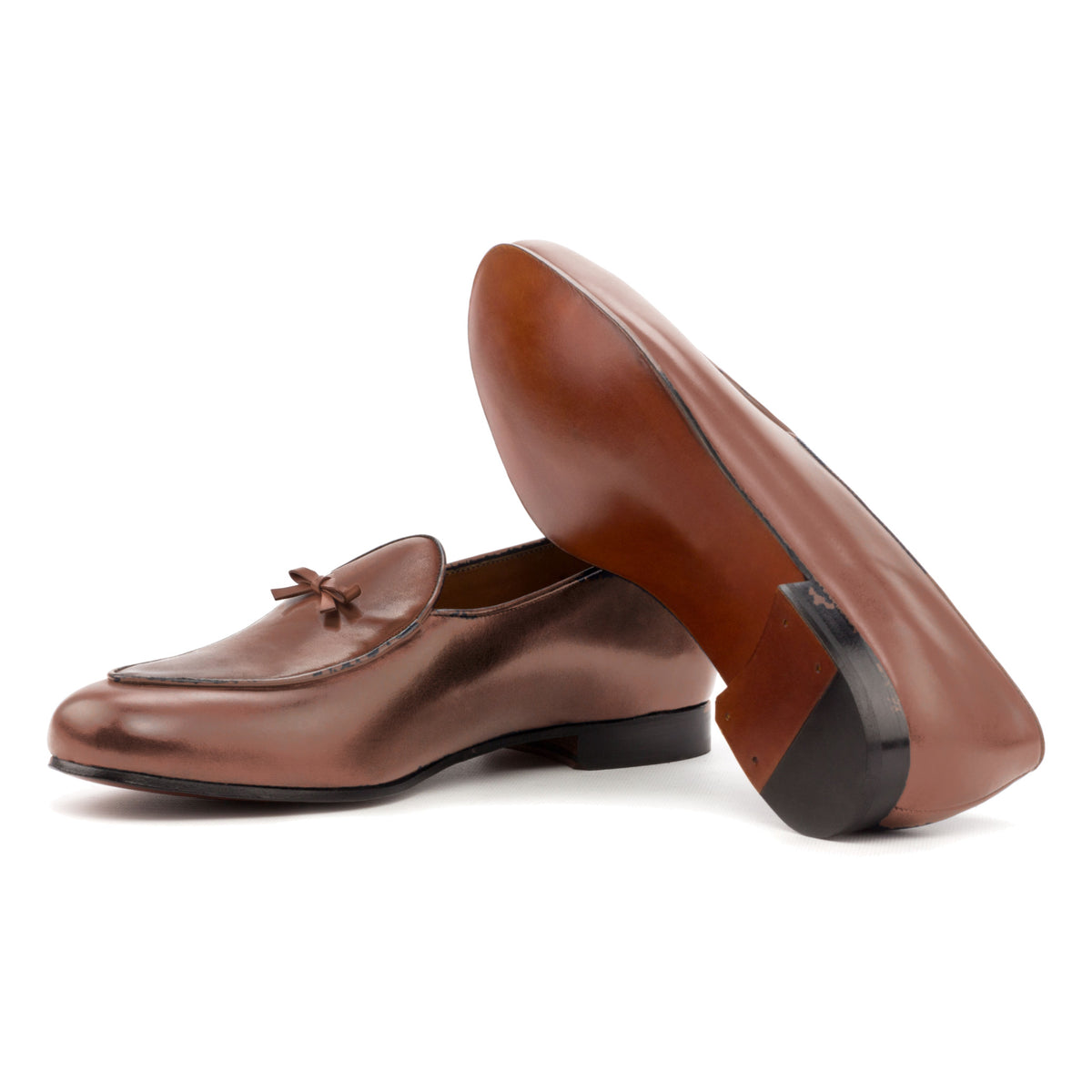 Mocassin belge en cuir teinté main marron moyen : une chaussure couchée montre la semelle