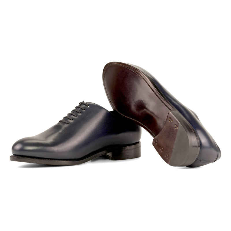 One Cut en cuir bleu marine, semelle cuir : une chaussure debout, l’autre couchée qui montre sa semelle