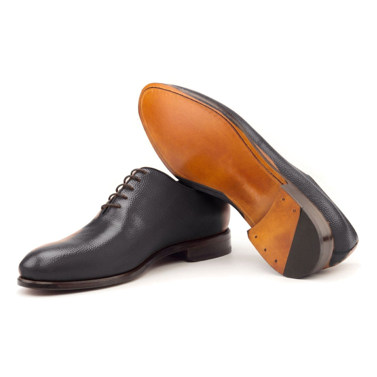 One Cut en cuir gros grain noir, semelle cuir : une chaussure debout, l’autre couchée montre sa semelle