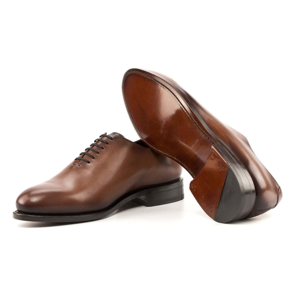 One Cut en cuir teinté main marron moyen, semelle cuir : une chaussure debout, l’autre couchée montre sa semelle