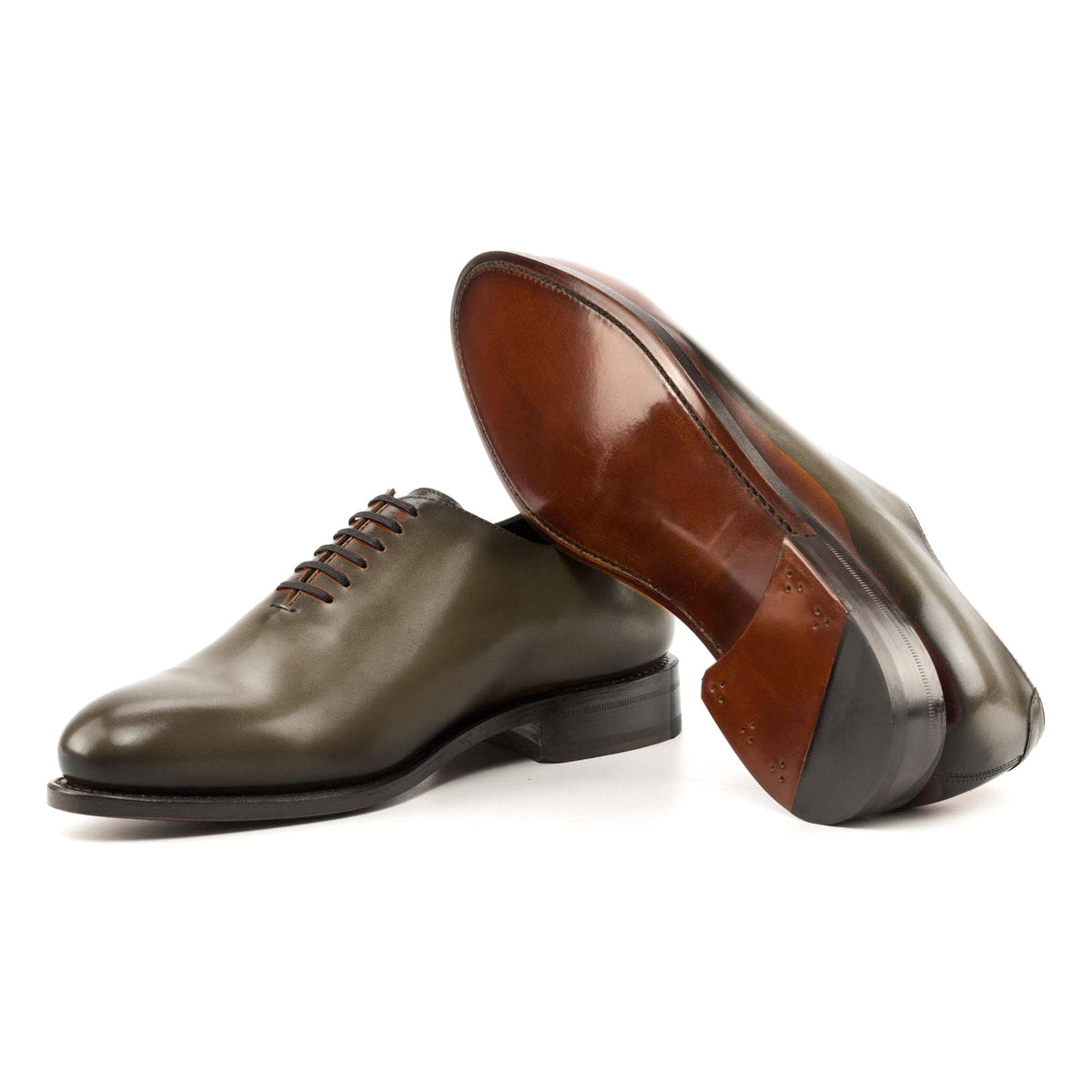 One Cut en cuir teinté main vert olive, semelle cuir : une chaussure debout, l’autre couchée montre sa semelle