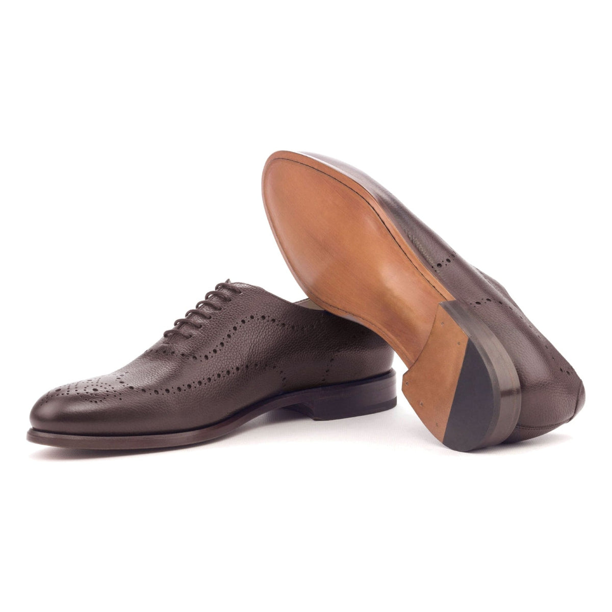 One Cut perforé en cuir grainé bordeaux, semelle cuir : une chaussure debout, l’autre couchée montre sa semelle