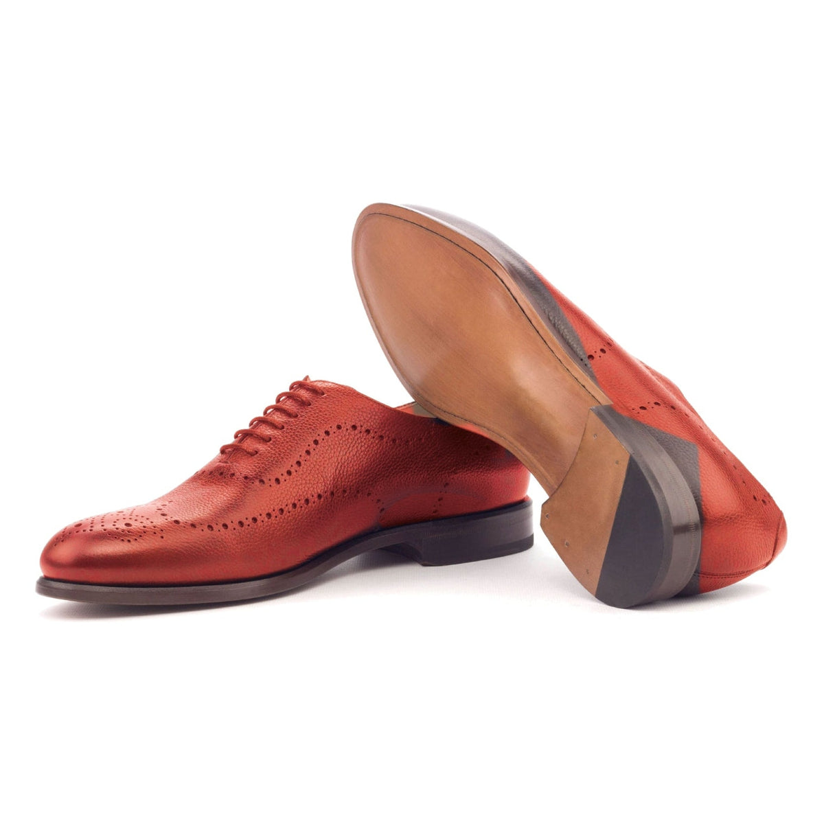 One Cut perforé en cuir grainé rouge, semelle cuir : une chaussure debout, l’autre couchée montre sa semelle