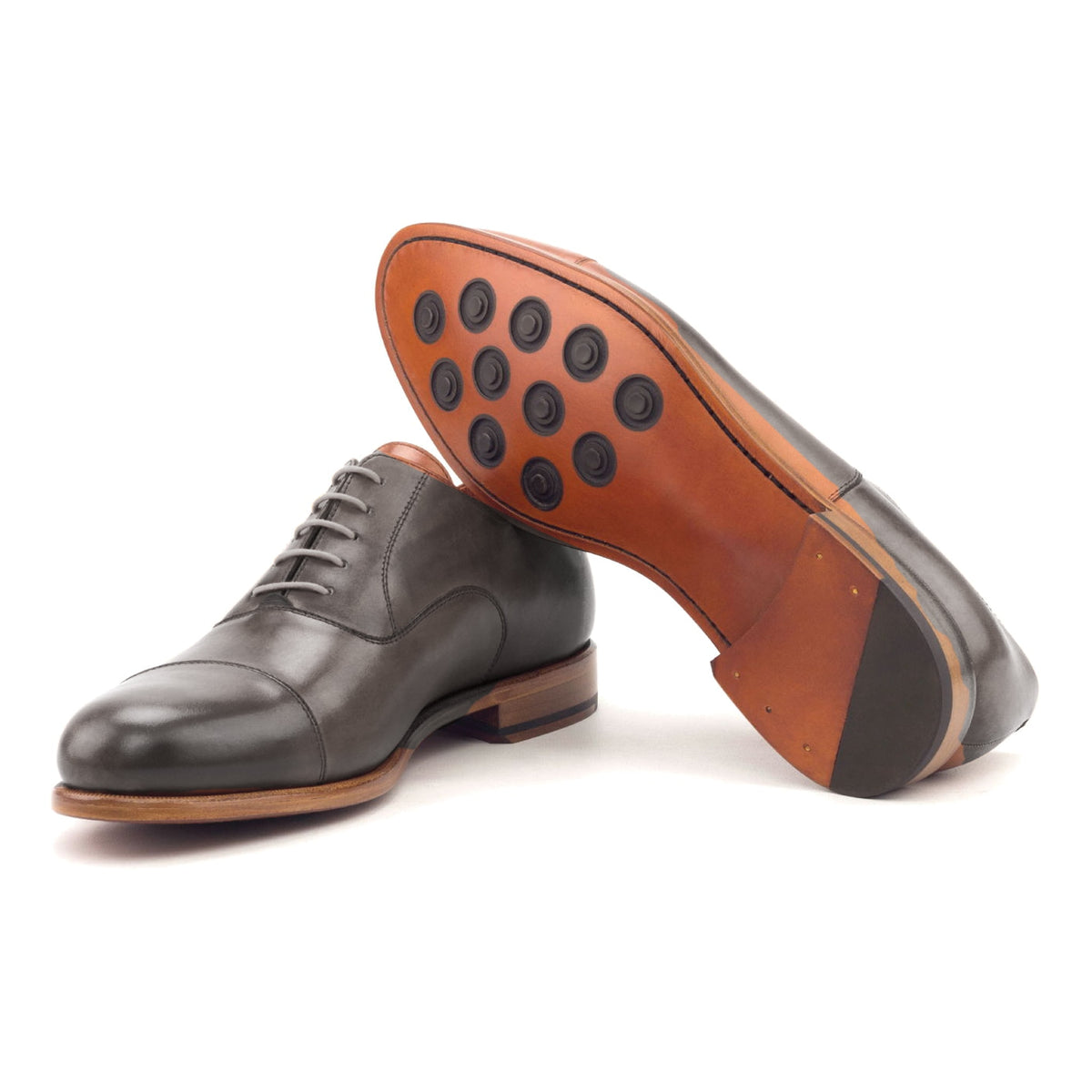 Richelieu bout droit en cuir teinté main gris, semelle cuir Buttons : une chaussure debout, l’autre couchée montre sa semelle
