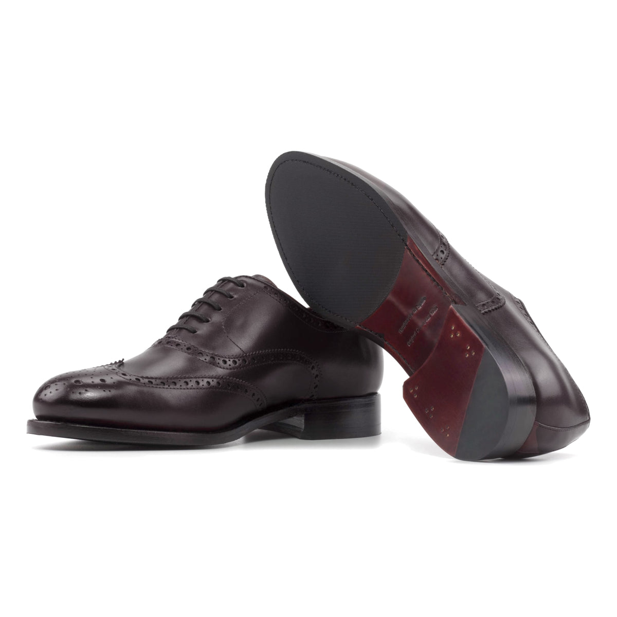 Richelieu fleuri en cuir sang-de-bœuf, semelle cuir et patin : une chaussure debout, l’autre couchée montre sa semelle