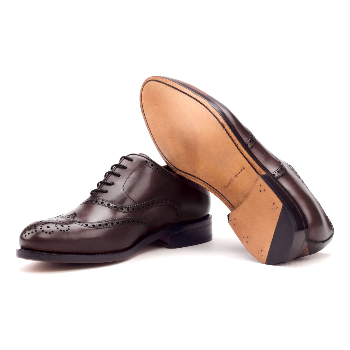 Richelieu fleuri en cuir teinté main bordeaux, semelle cuir : une chaussure debout, l’autre couchée montre sa semelle