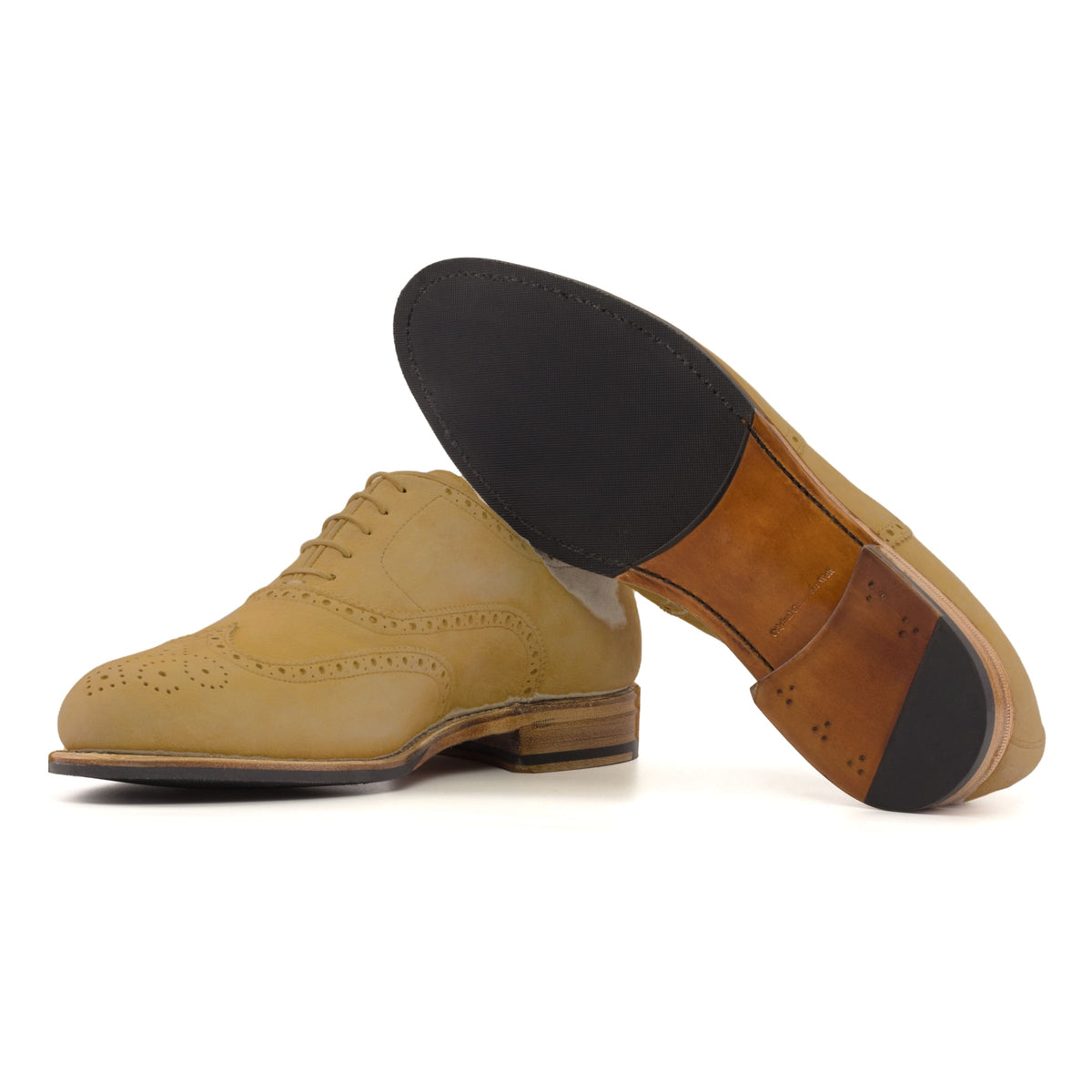 Richelieu fleuri en daim camel, semelle cuir et patin : une chaussure debout, l’autre couchée montre sa semelle