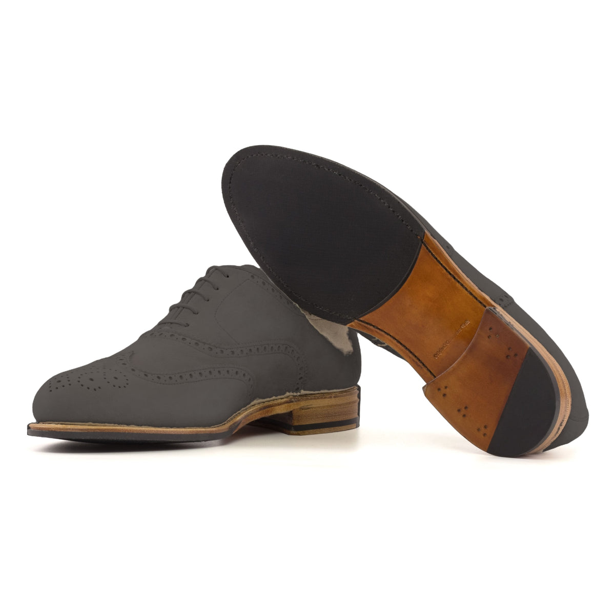 Richelieu fleuri en daim gris, semelle cuir et patin : une chaussure debout, l’autre couchée montre sa semelle