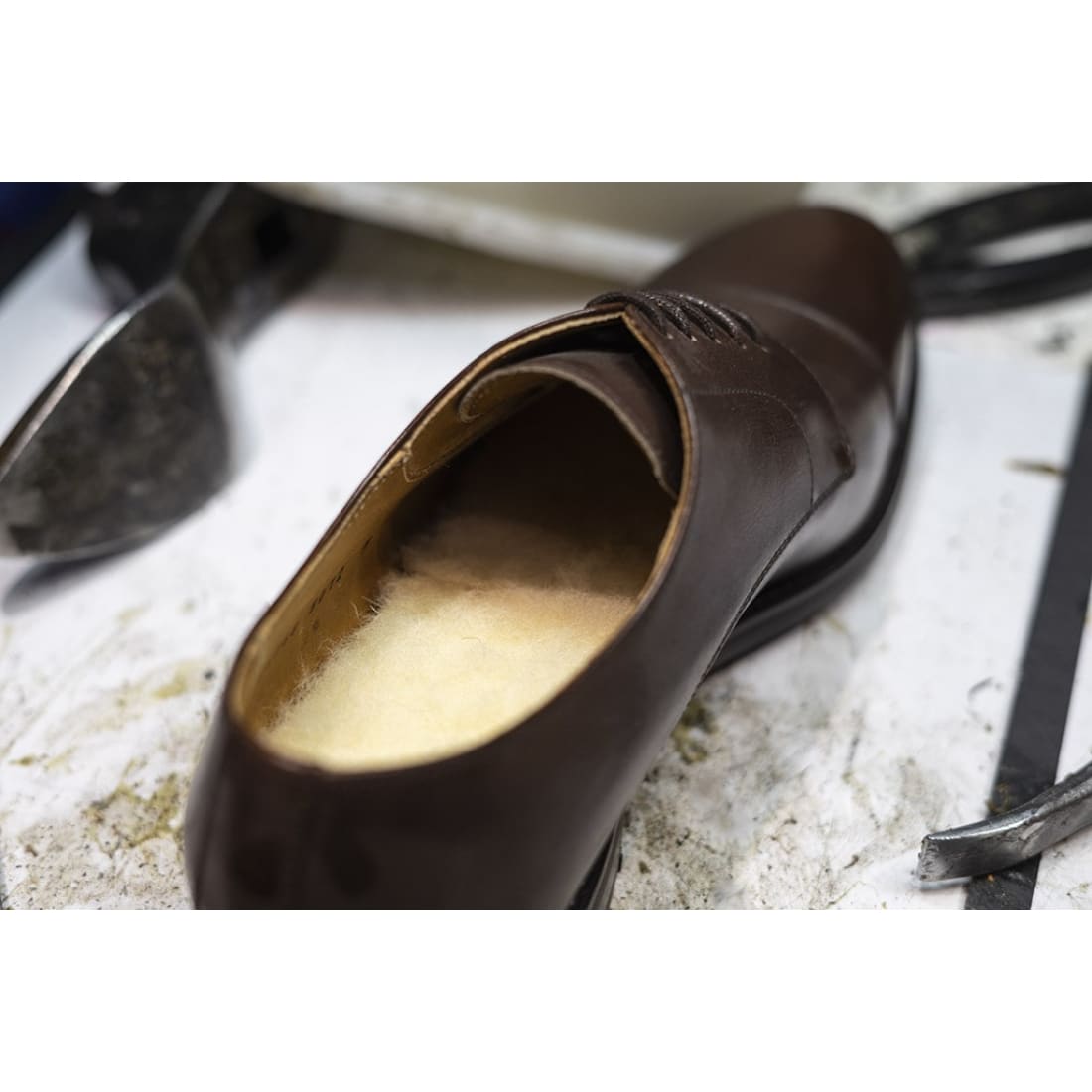 Semelle en laine posée dans un soulier en cuir marron.
